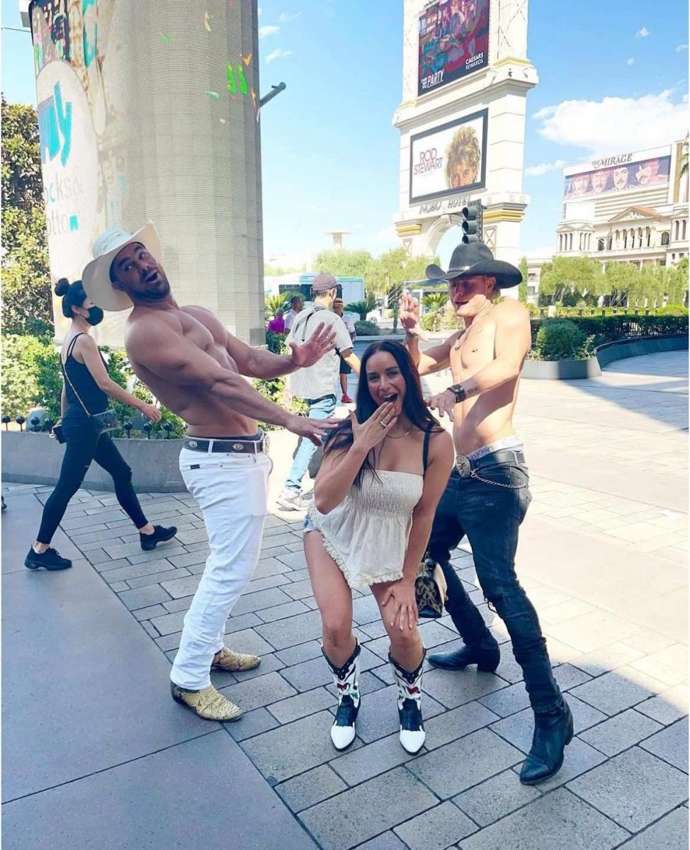 Traveller posing with cowboy street performers on the Las Vegas Strip in front of Caesars Palace.