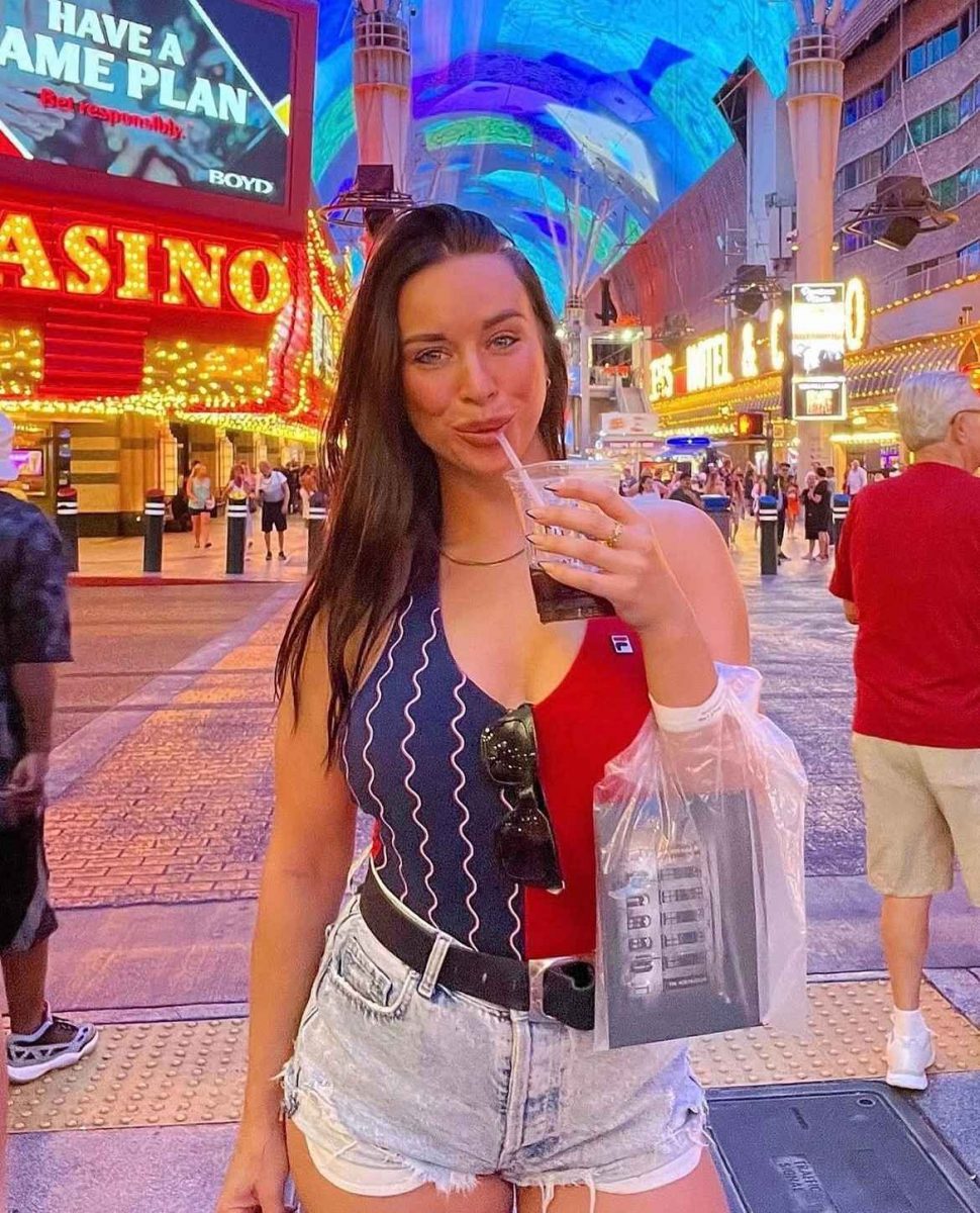 Travel writer enjoying a drink on Fremont Street in downtown Las Vegas, surrounded by neon lights and casino signs.
